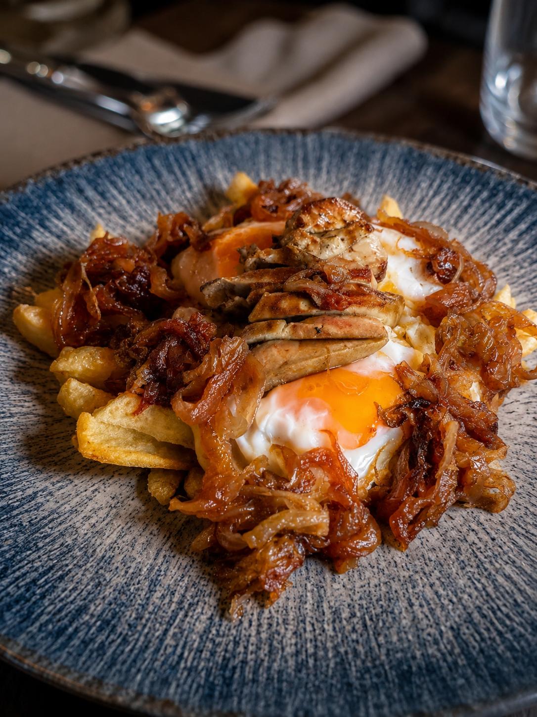 Huevos rotos con foie y cebolla caramelizada
